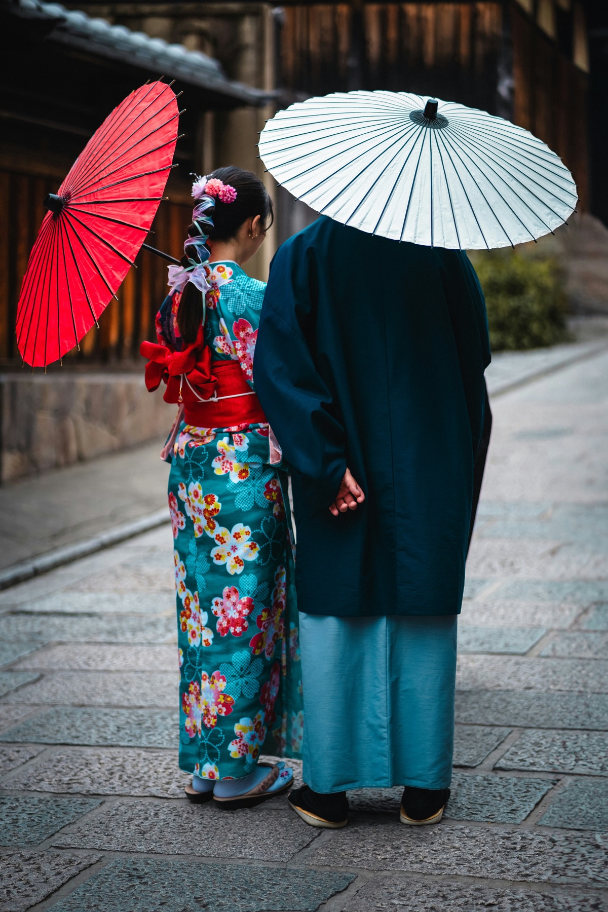 Couple in kimono under paper umbrellas