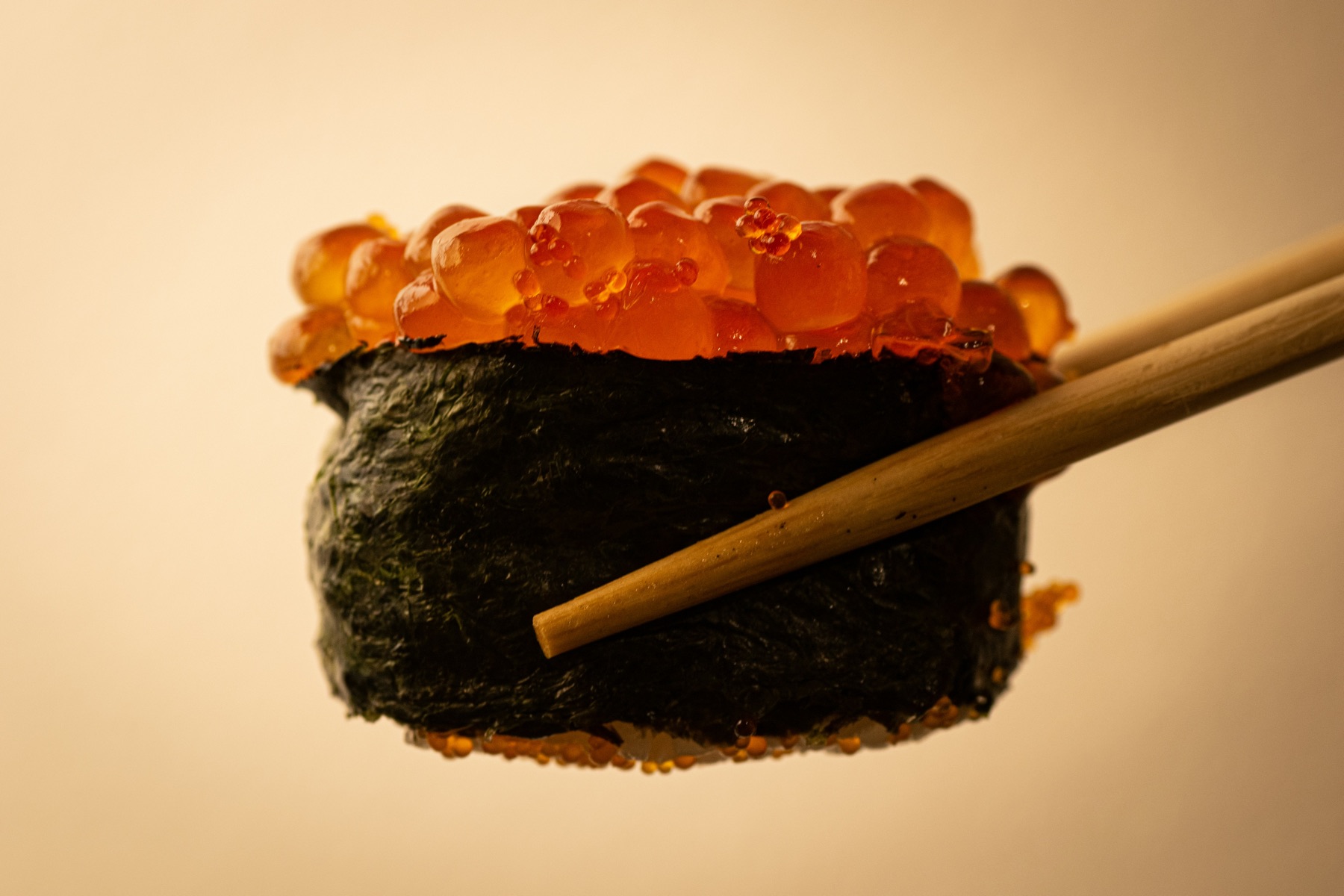 Ikura gunkan held by chopsticks